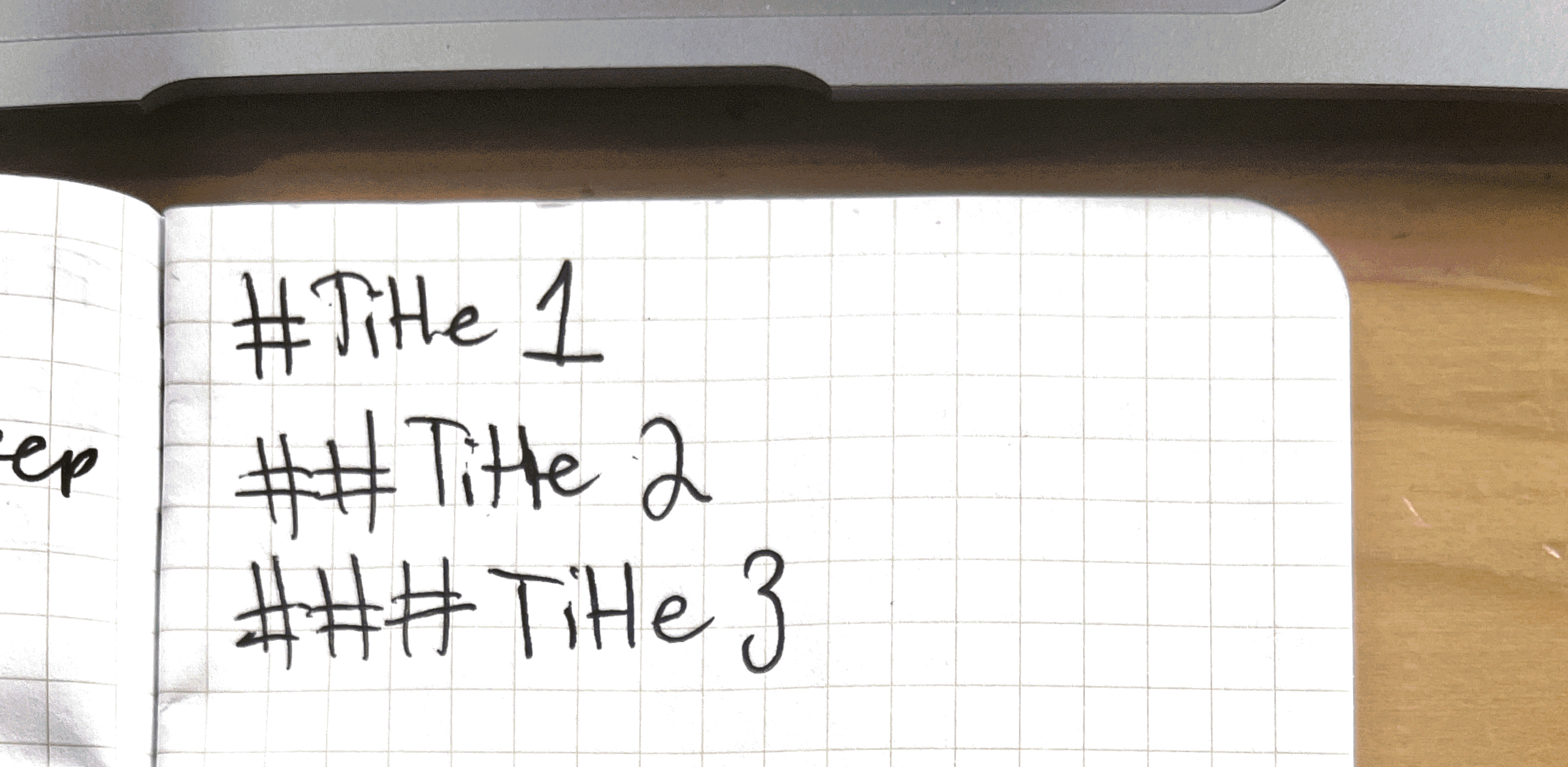 Titles Close-up photo of a handwritten note on grid paper: #Title 1, ##Title 2, and ###Title 3 on seperate lines